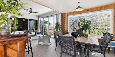 Bright and airy sunroom featuring ample greenery and spacious dining area for leisurely gatherings.