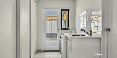 Bright and functional laundry area featuring ample storage and easy access to an outdoor space.