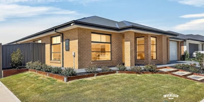 Modern home featuring extensive windows, well-kept landscaping, and a spacious driveway in a desirable neighborhood.