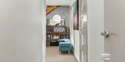 Bright and inviting hallway leads to an open living area, showcasing ample shelving and natural light.