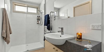 Modern bathroom featuring a spacious shower, sleek fixtures, and ample natural light, perfect for relaxation.