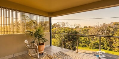 Enjoy morning light and nature views from this inviting balcony, perfect for relaxation or coffee.