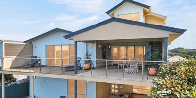 This contemporary home features spacious outdoor living areas and large windows that invite abundant natural light.