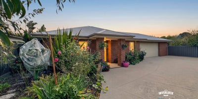 Beautifully landscaped exterior with vibrant garden, inviting entrance, and ample parking space for multiple vehicles.
