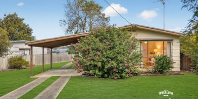 Cozy home featuring expansive green lawns and a covered carport, ideal for outdoor living.