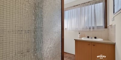 Bright bathroom featuring a spacious layout, large window for natural light, and practical design elements.