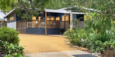 Bright, inviting home set on a spacious lot with a welcoming deck and lush landscaping.