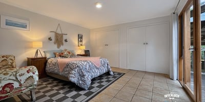 Spacious bedroom featuring ample storage, natural light, and direct access to the outdoor patio.