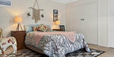 Cozy bedroom featuring botanical decor, abundant natural light, and ample storage for comfortable living.