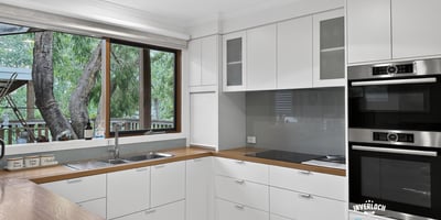 Modern kitchen featuring sleek cabinetry, quality appliances, and abundant natural light from large windows.