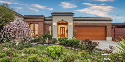 This inviting home features vibrant landscaping, a spacious garage, and a welcoming entryway.