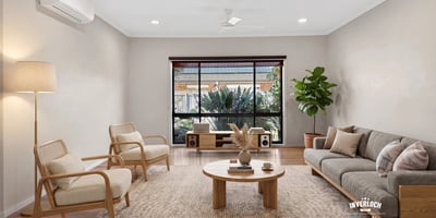 Bright living area features large windows, natural light, and modern furnishings, ideal for relaxed gatherings.