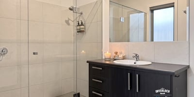 Modern bathroom featuring a spacious shower, sleek cabinetry, and natural light for a refreshing ambiance.