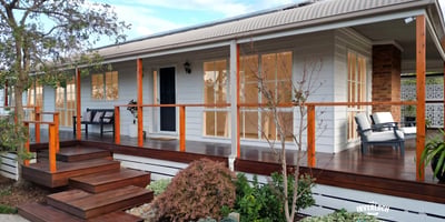 Discover a beautifully designed home featuring a welcoming porch and well-maintained landscaping, perfect for outdoor enjoyment.