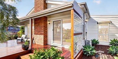Inviting home features a spacious deck and lush landscaping, perfect for outdoor gatherings and relaxation.