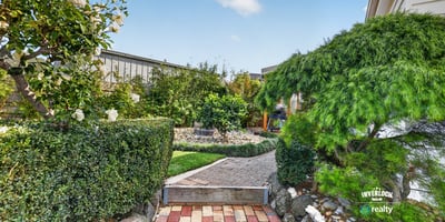 Discover a beautifully landscaped garden pathway surrounded by lush greenery and vibrant plant life.