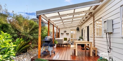 Spacious covered patio with ample seating and outdoor grilling area, perfect for entertaining and relaxing.