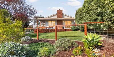 Discover a beautifully landscaped property featuring a spacious backyard with vibrant greenery and ample outdoor space.