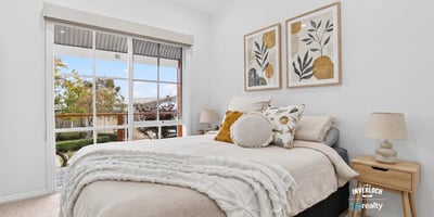 Bright and inviting bedroom featuring large windows, modern decor, and a cozy atmosphere for relaxation.