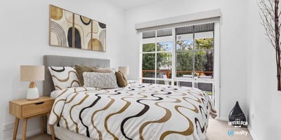 Bright bedroom featuring large windows, modern decor, and a cozy layout, ideal for relaxation and rest.