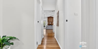 Bright, inviting hallway leading to a spacious living area, showcasing modern design and warmth throughout.