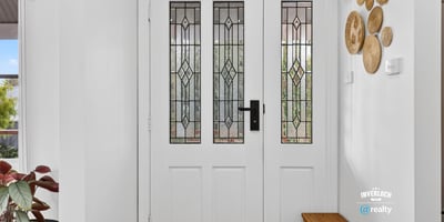 Inviting entryway featuring detailed glass doors and unique wall decor, perfect for welcoming guests.