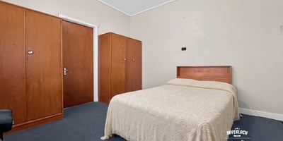 Spacious bedroom featuring a queen-size bed and built-in wardrobes, perfect for personalizing your space.