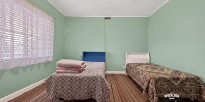Bright and spacious bedroom with ample natural light, featuring two beds and distinctive patterned accents.