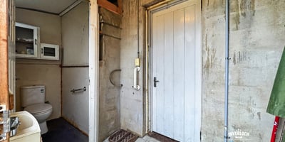 Functional entryway featuring a convenient bathroom and access to additional storage options.