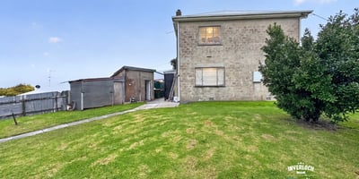 Spacious two-story home on a generous lot, featuring ample outdoor space and a detached shed.