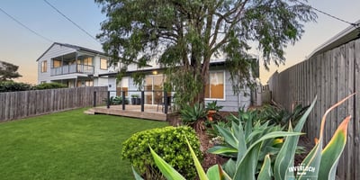 Spacious backyard with lush greenery, perfect for outdoor gatherings and relaxation near a modern home.