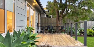 Discover a welcoming outdoor space featuring a spacious deck and lush greenery, perfect for relaxation.