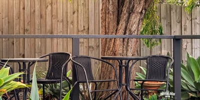 This inviting outdoor space features comfortable seating surrounded by lush greenery, perfect for relaxation or gatherings.