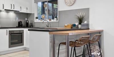 Modern kitchen featuring sleek cabinetry, a cozy breakfast bar, and ample natural light for culinary inspiration.