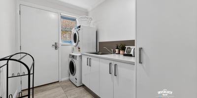 Bright and functional laundry area featuring modern appliances and practical storage solutions to enhance convenience.