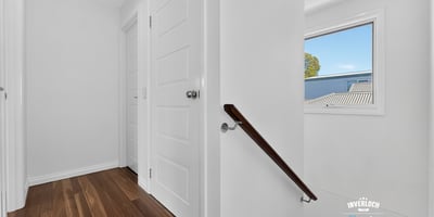 Bright and inviting hallway featuring warm wood flooring and ample natural light from the window.
