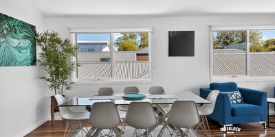 Bright dining area featuring large windows, modern furnishings, and an inviting atmosphere perfect for gatherings.