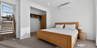 Bright and airy bedroom featuring a spacious layout, modern air conditioning, and abundant natural light.