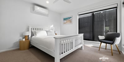 Bright and airy bedroom featuring large windows, modern furnishings, and a cozy atmosphere for relaxation.