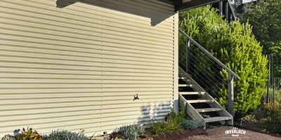 Modern exterior featuring a sleek design, landscaped garden, and convenient access via inviting stairs.