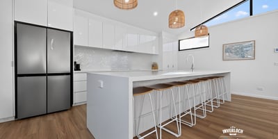 Modern kitchen featuring sleek cabinetry, a spacious island, natural light, and contemporary pendant lighting.