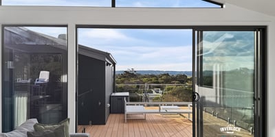 Bright and airy living space opens to a spacious deck, offering stunning views of the landscape.