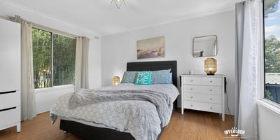 Spacious bedroom featuring abundant natural light, modern decor, and a cozy atmosphere for relaxation.