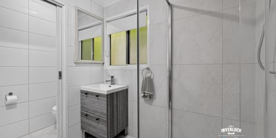 Modern bathroom featuring dual mirrors, a spacious shower, and sleek cabinetry for efficient storage.