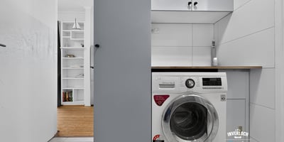 Compact laundry area featuring modern appliances and efficient storage solutions for optimal functionality.