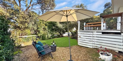 Inviting outdoor space features a shaded seating area, perfect for relaxation or entertaining amid lush greenery.