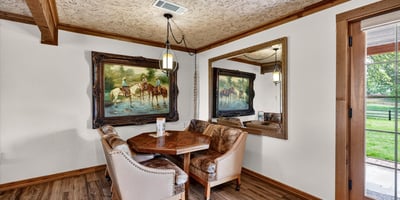 Cozy dining nook features natural light, unique artwork, and a welcoming atmosphere for intimate gatherings.