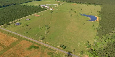 Spacious rural property featuring expansive pastures, a tranquil pond, and scenic views, ideal for development or recreation.