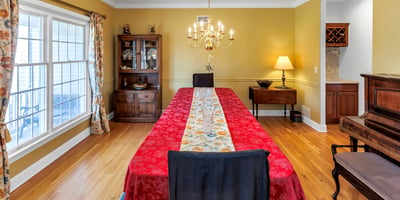 Dining Room has gleaming hardwood flooring. Afternoon sun streams through double windows.