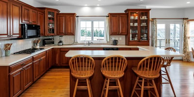Highlights of the beautiful Kitchen include cherry cabinets, tile backsplash, Island with breakfast bar, hardwood flooring, and recessed lighting.